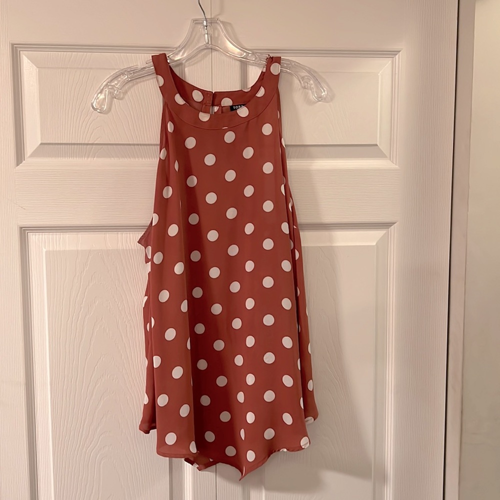 Polka dot sleeveless blouse.